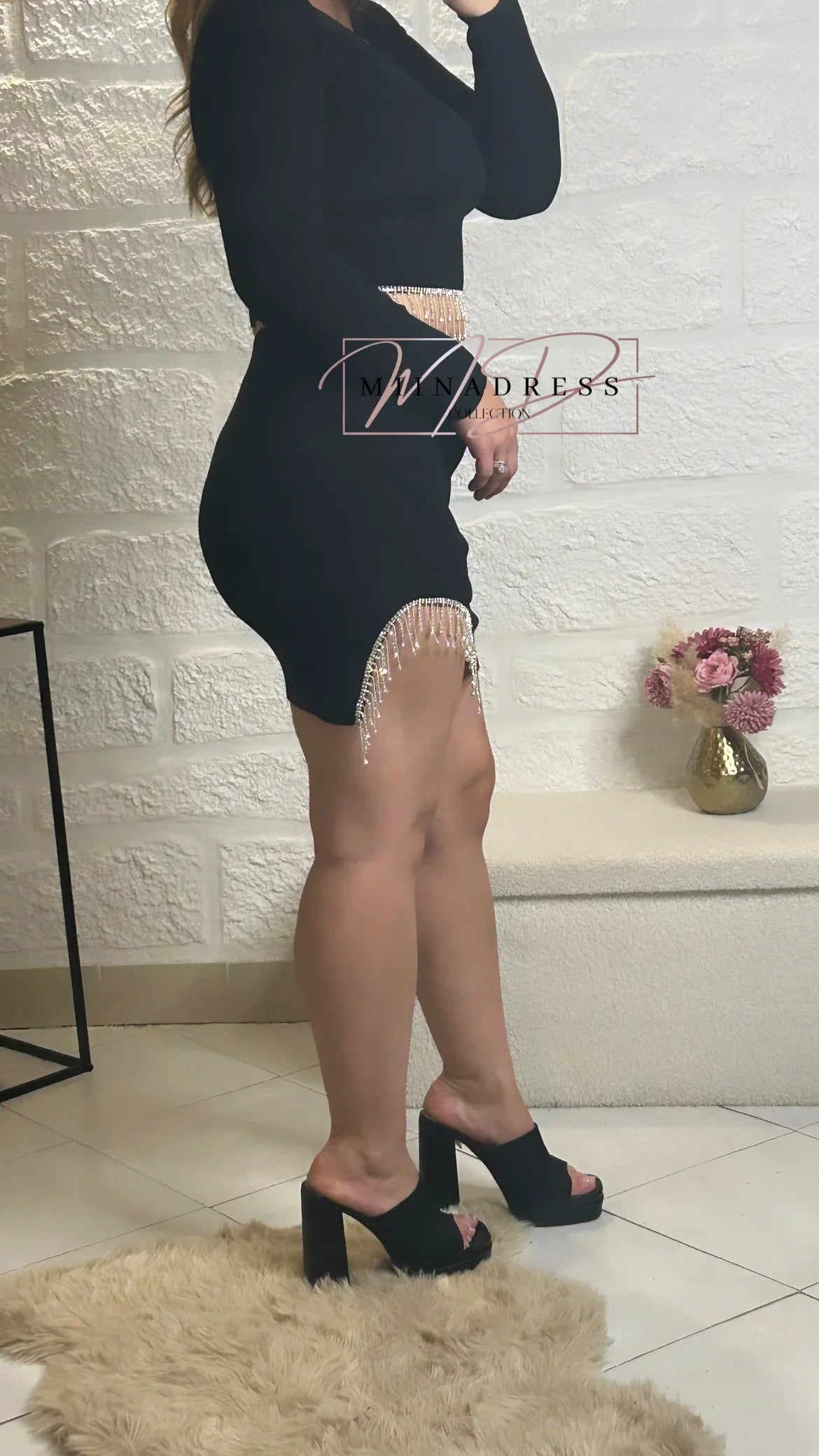 Robe noire moulante à manches longues avec franges strass, femme en sandales à talons