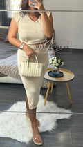 Femme en robe beige moulante, sac à main crème, sandales à talons, style chic décontracté