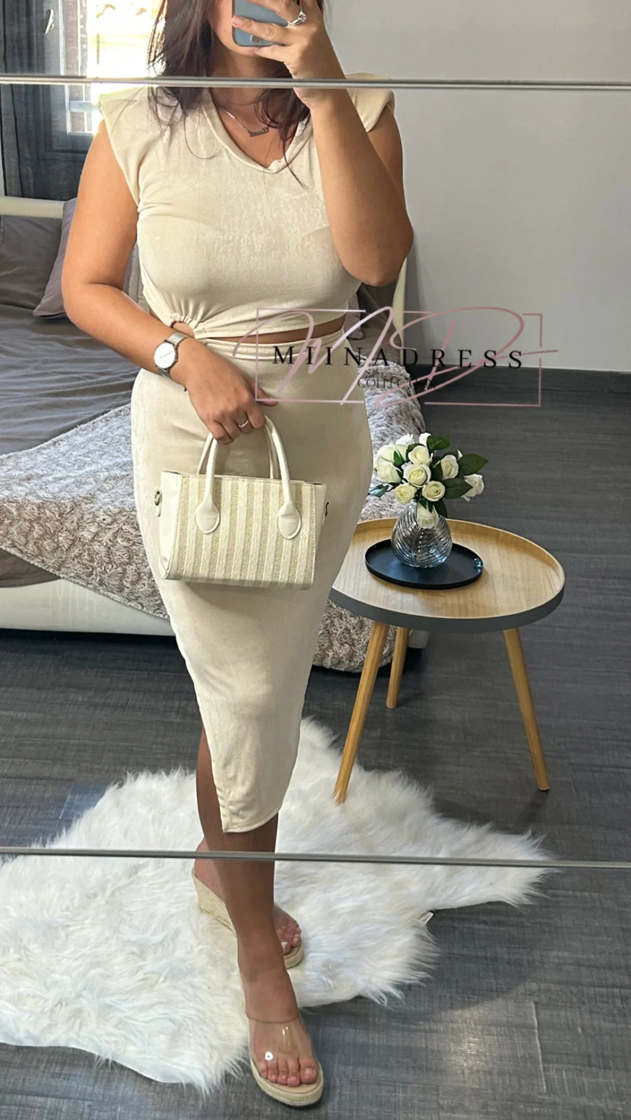 Femme en robe beige moulante, sac à main crème, sandales à talons, style chic décontracté